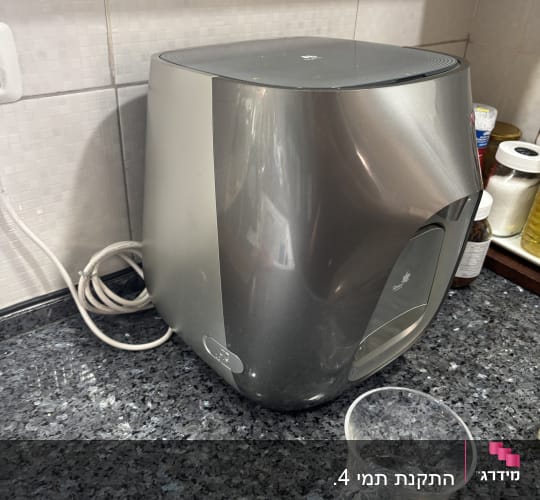 מכונת מים על משטח מטבח עם כוס פלסטיק